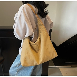 Detail showing oversized yellow hobo bag made of lightweight nylon with adjustable strap