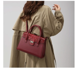 Detailsicht der roten Tragetasche mit Krokomuster, kombiniert mit einem Trenchcoat