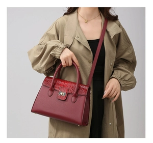 Modell mit burgunderroter Handtasche, Krokodil-Textur und edlem Metallverschluss-Detail