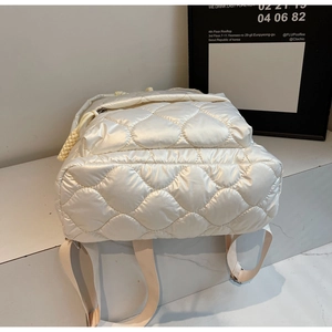 Macro shot of quilted down cotton backpack showing diamond stitching and zipper detail