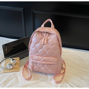 Detailed view of pink quilted down-filled backpack with woven zipper pullers and pockets