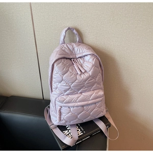 Close-up of lilac quilted nylon backpack featuring wavy embroidery and zipper detail
