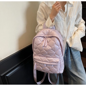 Close-up of lavender quilted backpack showing padded fabric texture and zipper detail