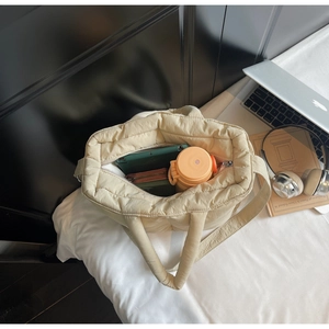 Detailed view of spacious interior storage in a beige quilted puffer tote bag