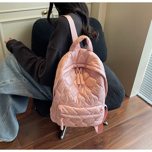 Detailed back view of pink quilted down-padded backpack with heart embroidery pattern