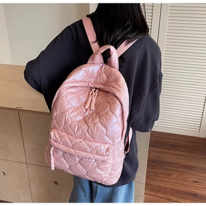 Close-up of pink heart-quilted down-filled backpack with lightweight padded texture
