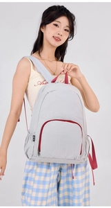Detail of grey lightweight foldable backpack with red accents and elastic side pockets