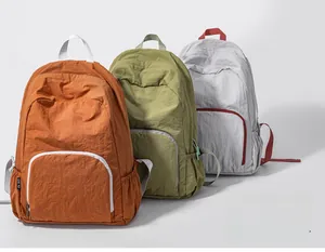 Foldable nylon backpack detail in orange, olive green and light grey wrinkled fabric
