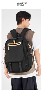 Detail of a black nylon backpack featuring brown accents and side buckles on the side
