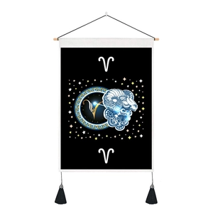 Detailed view of black Aries zodiac tapestry with wooden rod, starry pattern and tassels