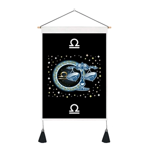 Detail of Libra zodiac wall hanging featuring wooden rod, gold constellation and black tassels