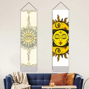 Vertical sun tapestry with tassels hanging over a sofa in a bohemian style room