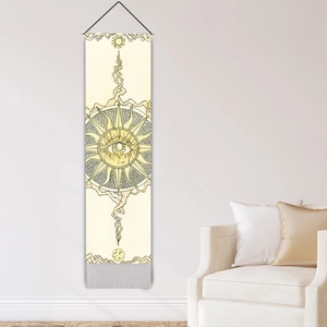 Bohemian sun eye tapestry with black tassels hanging on minimalist living room wall