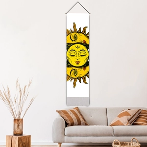 Bohemian sun and moon tapestry with tassels hanging above a minimalist sofa in a living room