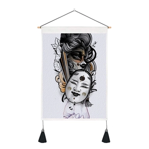 Detail of linen tapestry with traditional Japanese mask art and black tassel ornaments