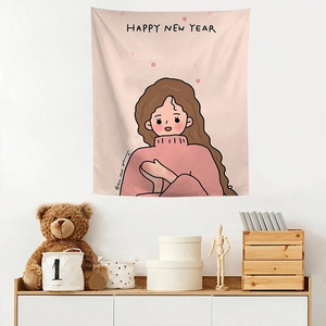 Detail of pink tapestry hanging on white wall with happy new year text and cartoon girl