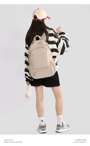 Detail view of cream white foldable backpack showing waterproof nylon texture and storage