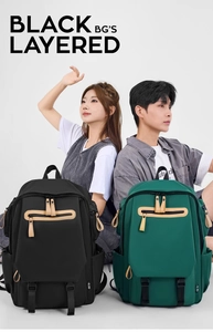 Detail view of black and dark green multi-pocket backpacks with leather zipper pulls