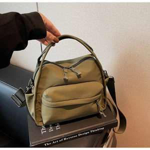 Detailaufnahme der olivgrünen Nylon-Umhängetasche mit verstellbarem Gurt und Reißverschluss