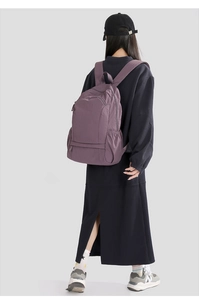 Detail of purple waterproof nylon backpack showing elastic side pocket and texture