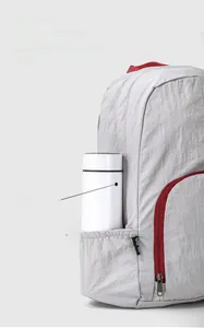 Close-up of light gray travel backpack showing durable fabric and side water bottle pocket
