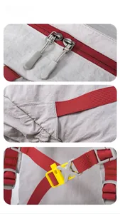 Detail view of grey nylon fabric with red zippers and yellow emergency whistle buckle