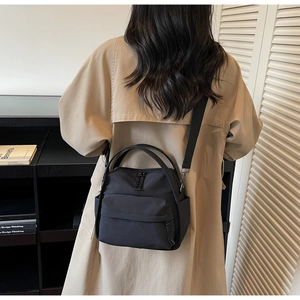 Vielseitige schwarze Nylon Umhängetasche mit mehreren Taschen am Modell