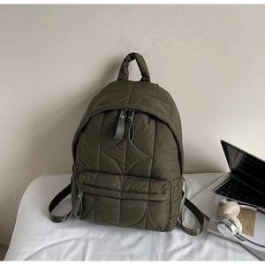 Dettaglio dello zaino trapuntato verde militare con trama in nylon e doppie cerniere