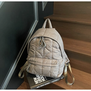 Vista dettagliata dello zaino trapuntato grigio con motivo a onde e scomparto con zip