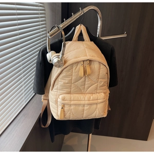 Dettaglio dello zaino trapuntato albicocca con texture imbottita e zip liscia