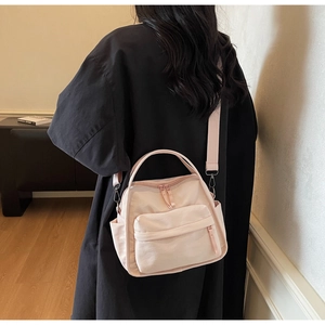 Detailansicht der leichten rosa Nylontasche mit praktischen Reißverschlussfächern