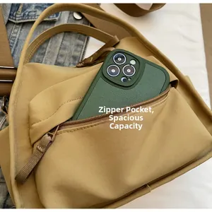 Detail der khaki Nylontasche mit Front-Reißverschlussfach und einem Smartphone