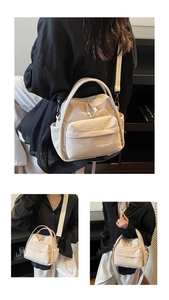 Detailansicht der beigefarbenen Nylontasche mit verstellbarem Gurt und Seitentaschen