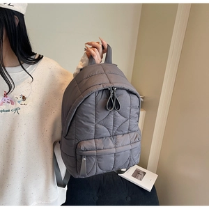 Dettaglio dello zaino in nylon trapuntato grigio con cuciture e cerniere rifinite