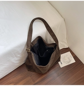 Vista dettagliata della borsa tote in pelle scamosciata marrone con tasche interne e tracolla