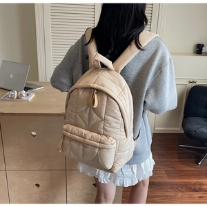 Dettaglio dello zaino trapuntato beige con imbottitura premium e tasca frontale a zip