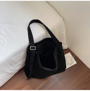Dettaglio della borsa shopper nera con tracolla larga e fibbia in oro opaco