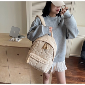 Dettaglio zaino trapuntato beige in nylon imbottito per uno stile quotidiano chic