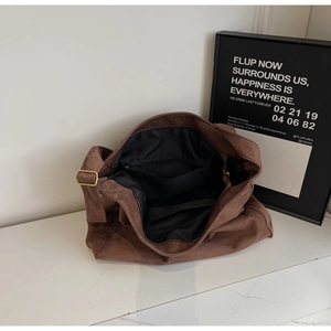 Dettaglio della borsa tote in pelle scamosciata marrone con fibbia in bronzo