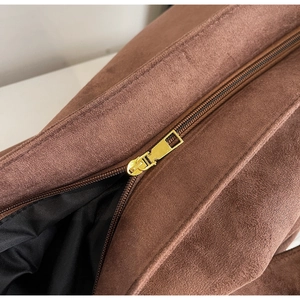 Dettaglio della cerniera dorata su una borsa tote in pelle scamosciata marrone foderata