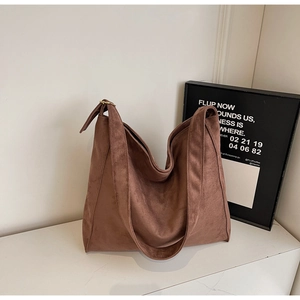 Dettaglio di una borsa hobo in pelle scamosciata marrone con consistenza morbida