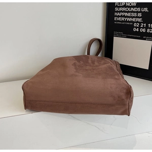 Dettaglio di una grande borsa tote vintage minimalista in finta pelle scamosciata.