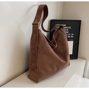 Dettaglio della borsa hobo in pelle scamosciata caramello con texture morbida e fibbia oro