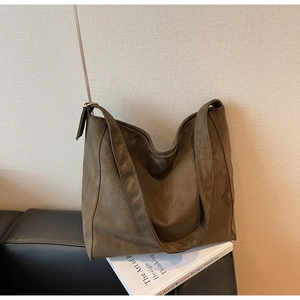 Dettaglio della borsa tote in pelle scamosciata verde oliva con fibbia in metallo