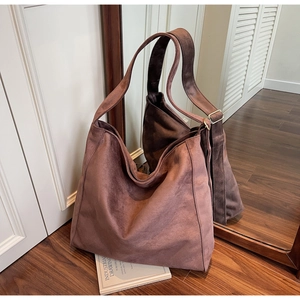 Dettaglio della borsa tote in pelle scamosciata malva con trama morbida e fibbia in metallo