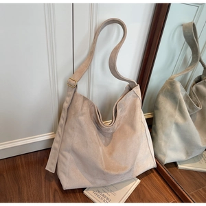 Dettaglio della borsa hobo in camoscio beige con tracolla regolabile e fibbia in metallo