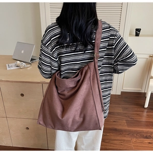 Dettaglio della borsa tote in pelle scamosciata marrone scuro con fibbia dorata vintage