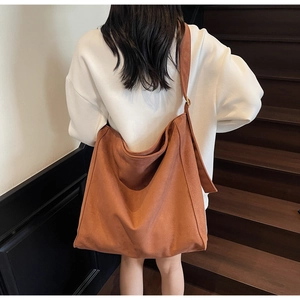 Dettaglio borsa tote in pelle scamosciata color caramello con tracolla regolabile