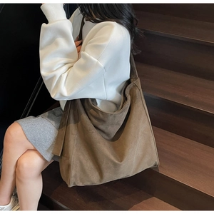 Borsa tote in pelle opaca marrone indossata da modella per riferimento alle dimensioni