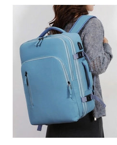 Side view of light blue business laptop backpack showing expansion straps and USB port